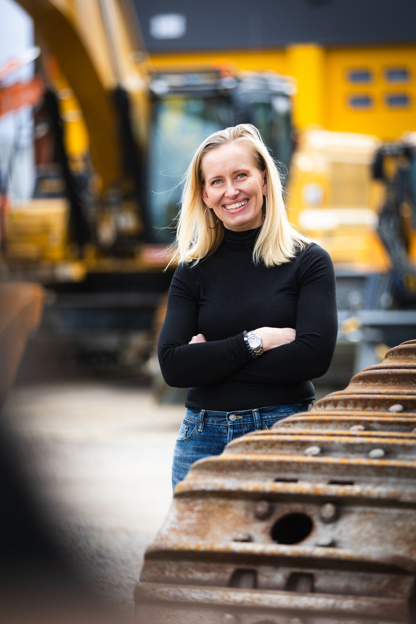 Milla Törmälä standing among excavators at a Vatupassi depot